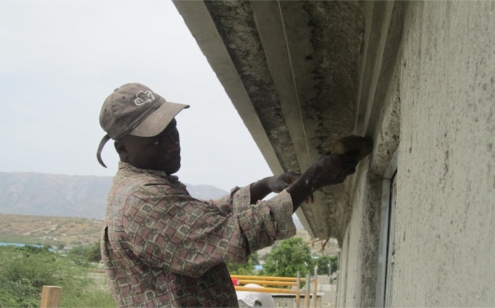 Plasterer Completing Molding on Orphanage.